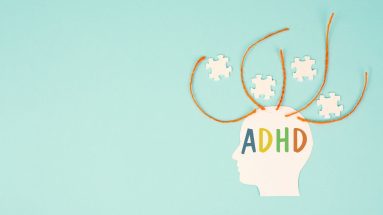 A baby blue background with a side view of a human head in white with ADHD in colorful text over the top portion. There are four orange threads coming out of the scalp with four white puzzle pieces arranged between the threads.