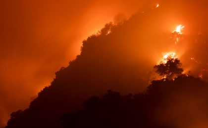 A wildfire burning on a forested hillside, similar to the scenes during the California wildfires of January 2025.